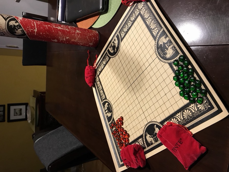 A game of Pente in progress on its board